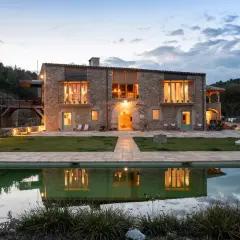 Casa rural en Pinell de Solsonès, con piscina y reflejos de luces cálidas.