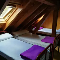 Refugio con ángulos de madera y camas sencillas, listo para recibir a viajeros.