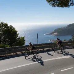 Ciclistas disfrutan del cicloturismo en Girona, con vistas al mar Mediterráneo y la costa.