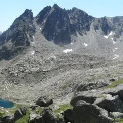 Majestuosas montañas rocosas y un lago azul turquesa en el valle de Aneu.