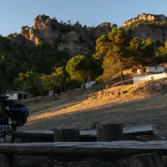 Bicicleta cargada para aventura, lista para explorar el GR 247 en bici. Paisaje montañoso al atardecer.