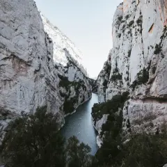 El río serpentea entre imponentes paredes rocosas en el congost de Montrebei. Pequeñas embarcaciones navegan tranquilamente por sus aguas.