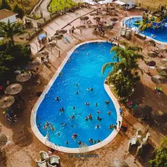 Disfruta de un día soleado en el camping Andalucía, con una gran piscina azul y toboganes acuáticos para toda la familia.