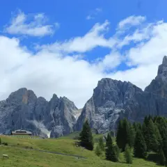 Majestuosas montañas de los Picos de Europa, un paisaje ideal para recorrer con tu camper. Nubes blancas adornan el cielo azul.