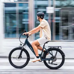 Hombre en bicicleta eléctrica, disfrutando de una marcha cicloturista urbana. El fondo borroso sugiere movimiento rápido y moderno.