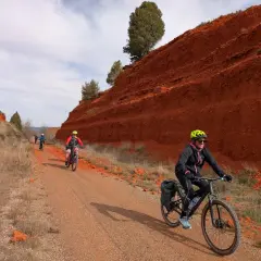 Ciclistas disfrutan de una **vía verde** con **ojos negros** en el paisaje rojizo.