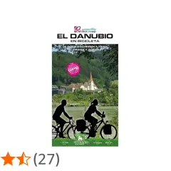 Ruta en bici por el Danubio, de Alemania a Austria. Paisaje fluvial con ciclistas y un pueblo con iglesia.