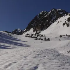 Paisaje invernal en Grau Roig, con montañas nevadas y cielo azul intenso.
