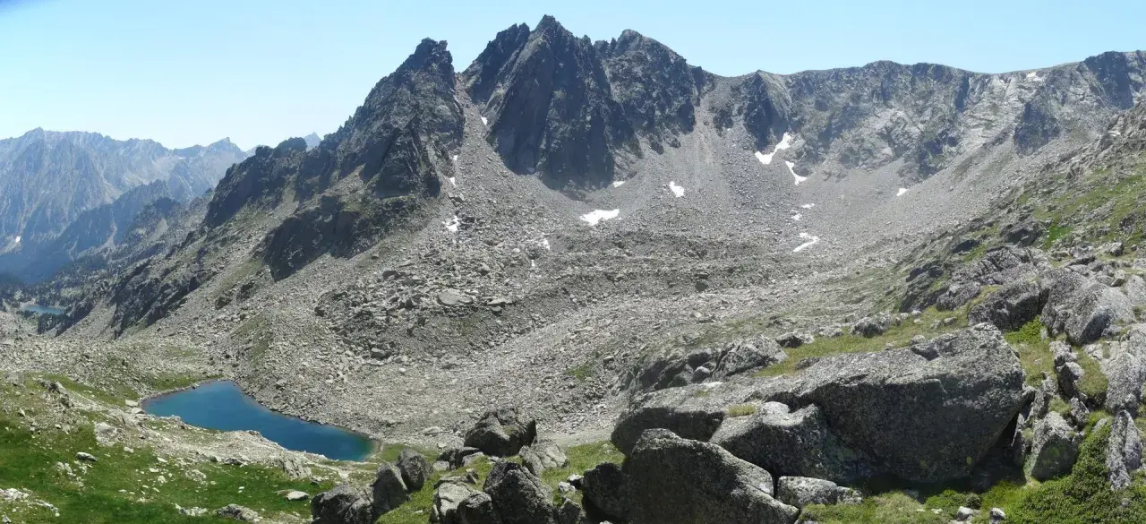 Majestuosas montañas rocosas y un lago azul turquesa en el valle de Aneu.