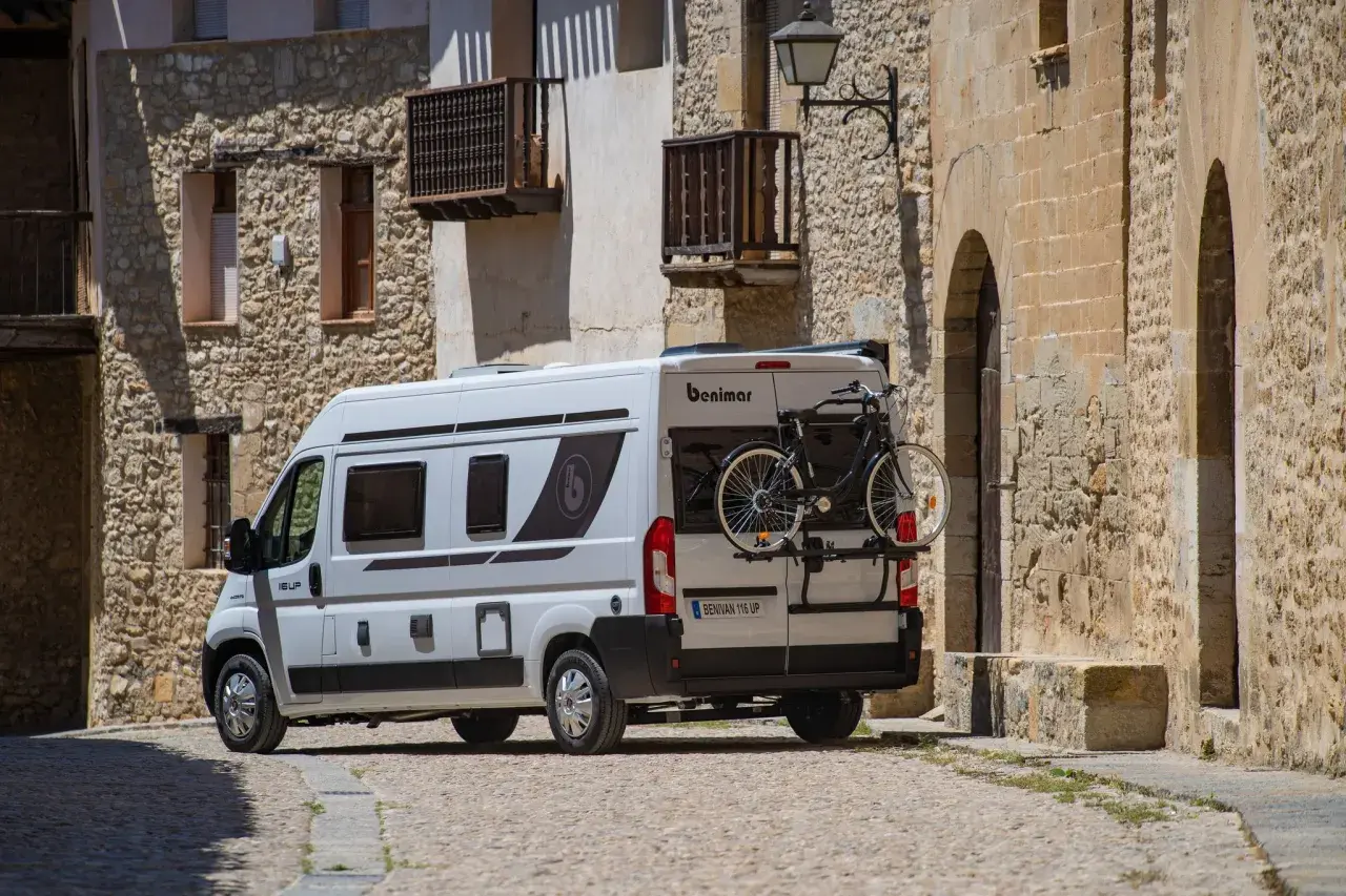 Furgoneta blanca con portabicicletas trasero, mostrando cómo llevar la bici dentro de la furgoneta para aventuras.