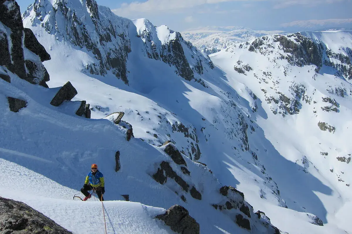 Alpinista en pendiente nevada, listo para ascender. Una escena perfecta para cursos de alpinismo.