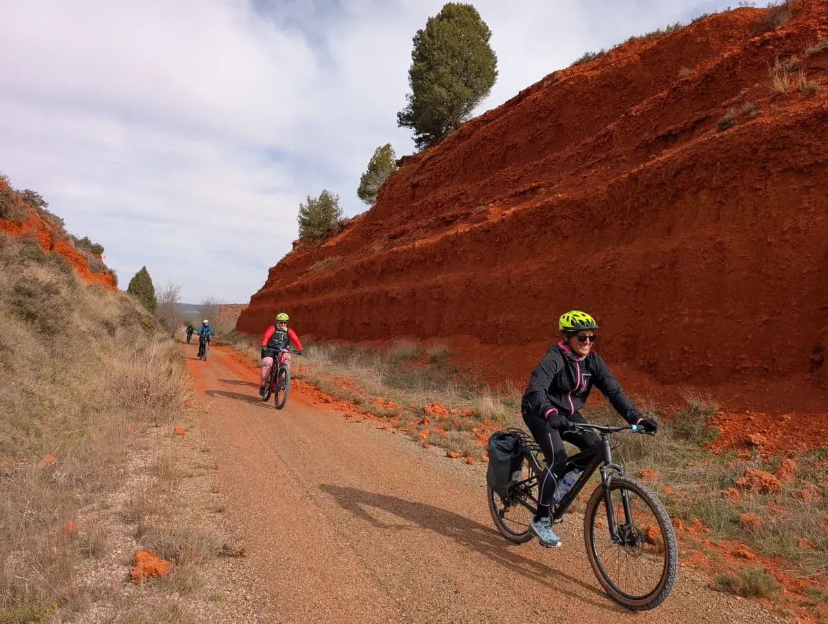 Ciclistas disfrutan de una **vía verde** con **ojos negros** en el paisaje rojizo.