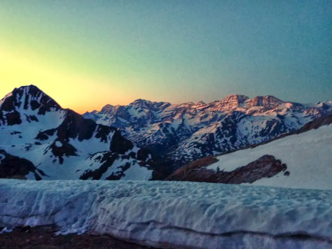 Majestuosas montañas nevadas bajo un cielo crepuscular, con el pico Viñamala asomando entre las cumbres.