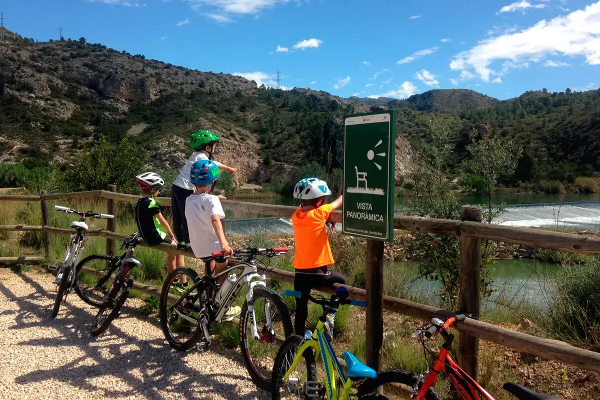 Niños en bicicleta disfrutan de la vista panorámica en la vía verde Val de Zafán.
