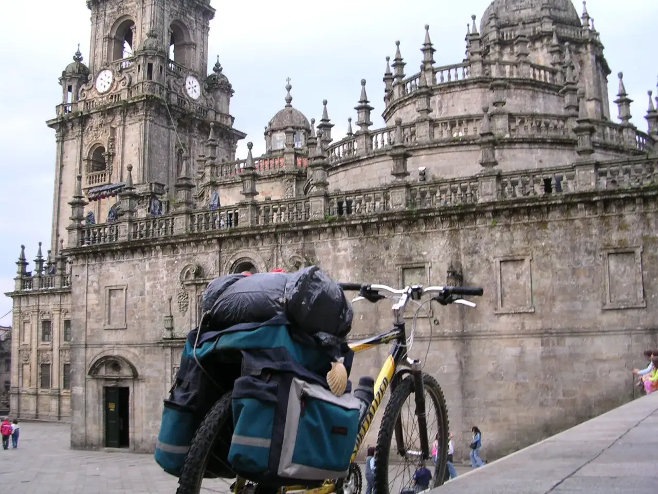 Bicicleta cargada lista para el camino de Santiago en bici, frente a la imponente Catedral de Santiago.