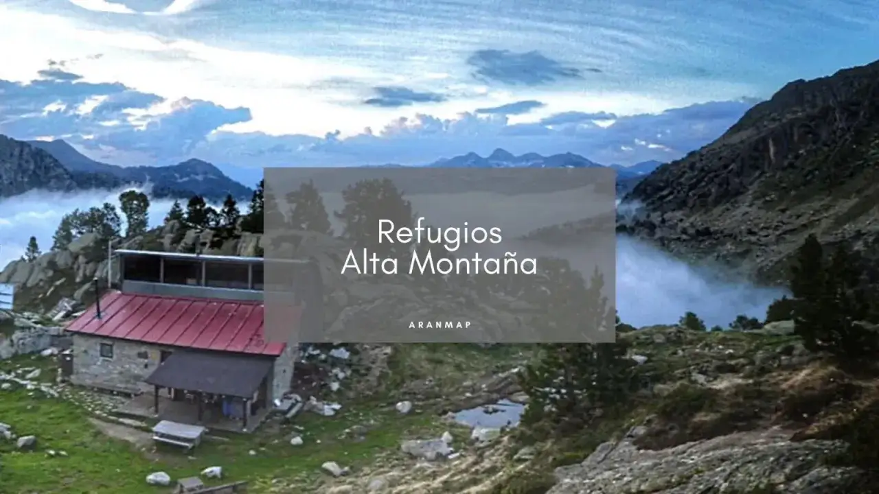 Refugi restanca en alta montaña, rodeado de picos y niebla.