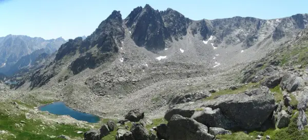 Majestuosas montañas rocosas y un lago azul turquesa en el valle de Aneu.